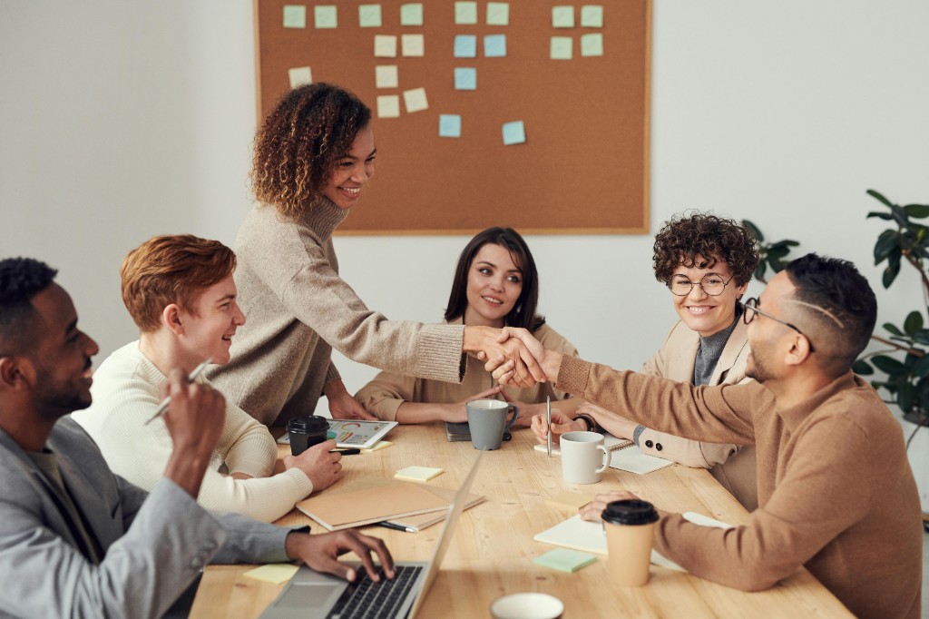 Professionals die samenwerken rond een vergadertafel, brainstormen en plannen in een moderne consultancy-omgeving